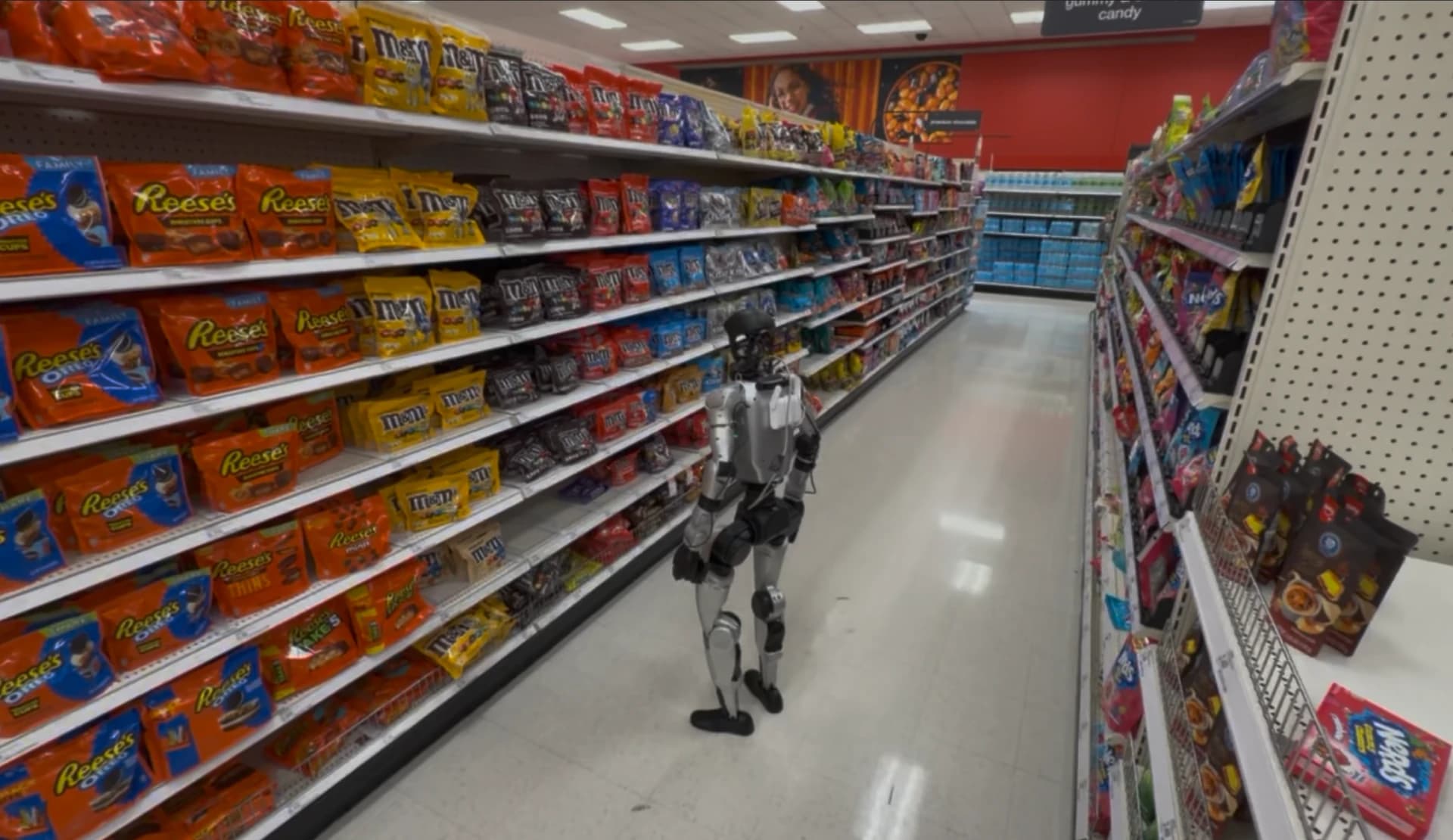 Project Meeseeks humanoid robot standing beside product shelves in a real retail aisle.
